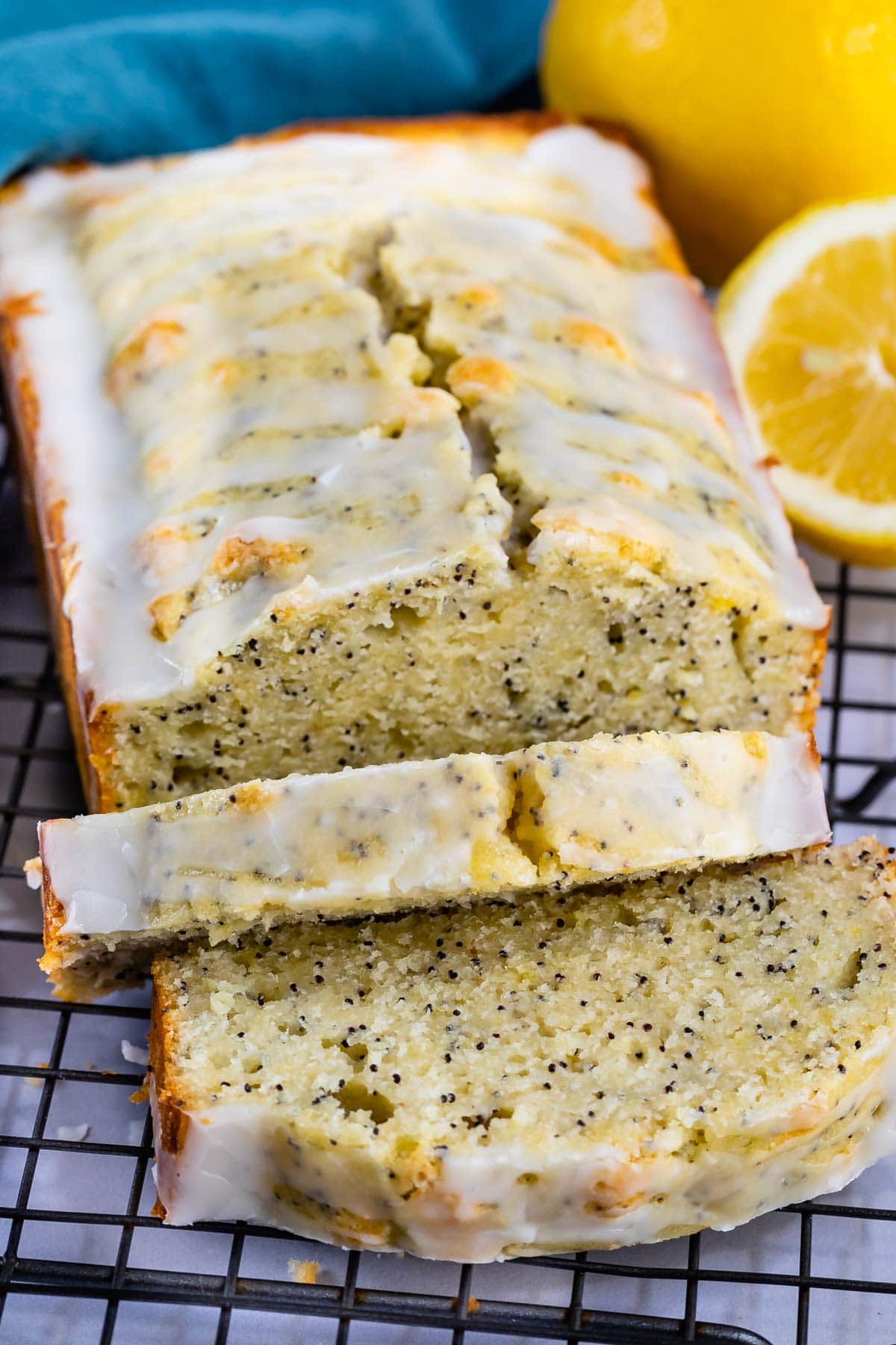 Lemon poppyseed bread loaf with two slices cut off and laid in front of loaf