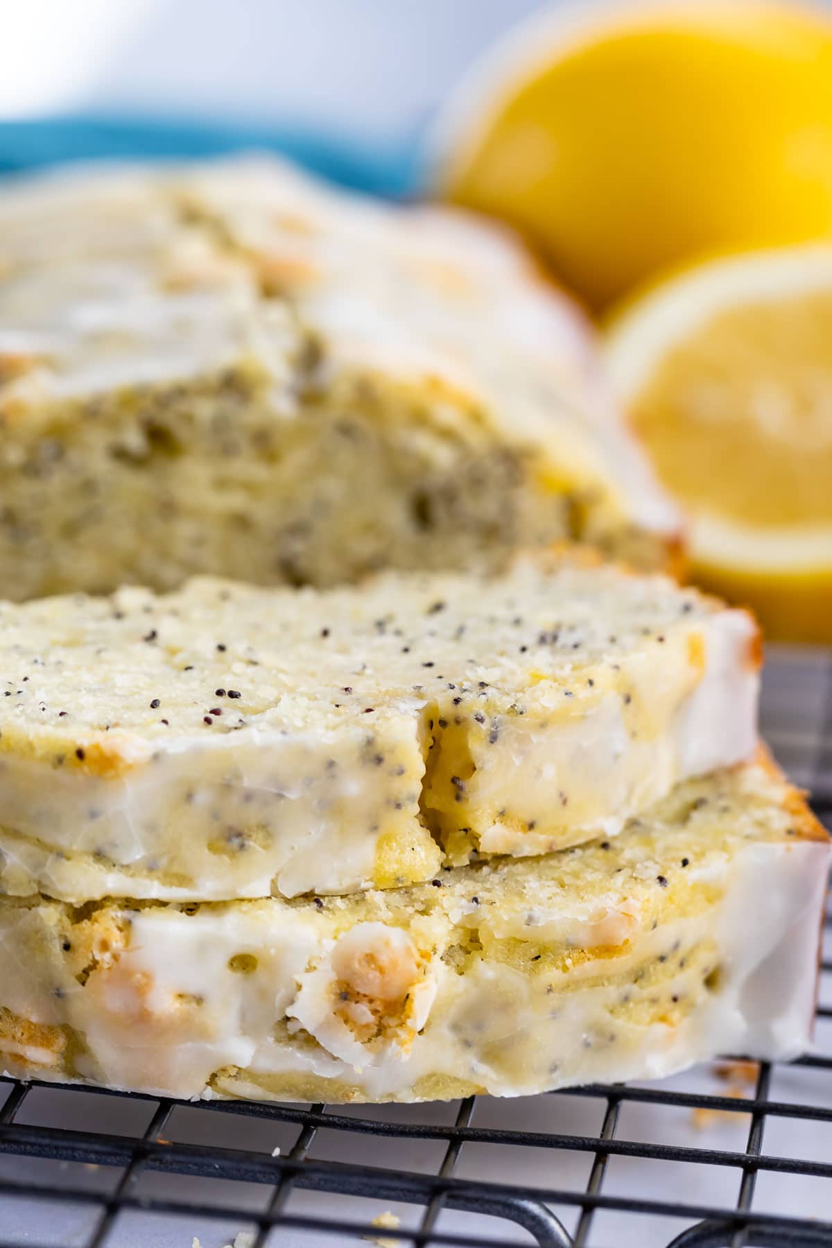 Lemon poppyseed bread loaf with two slices cut off and laid in front of loaf