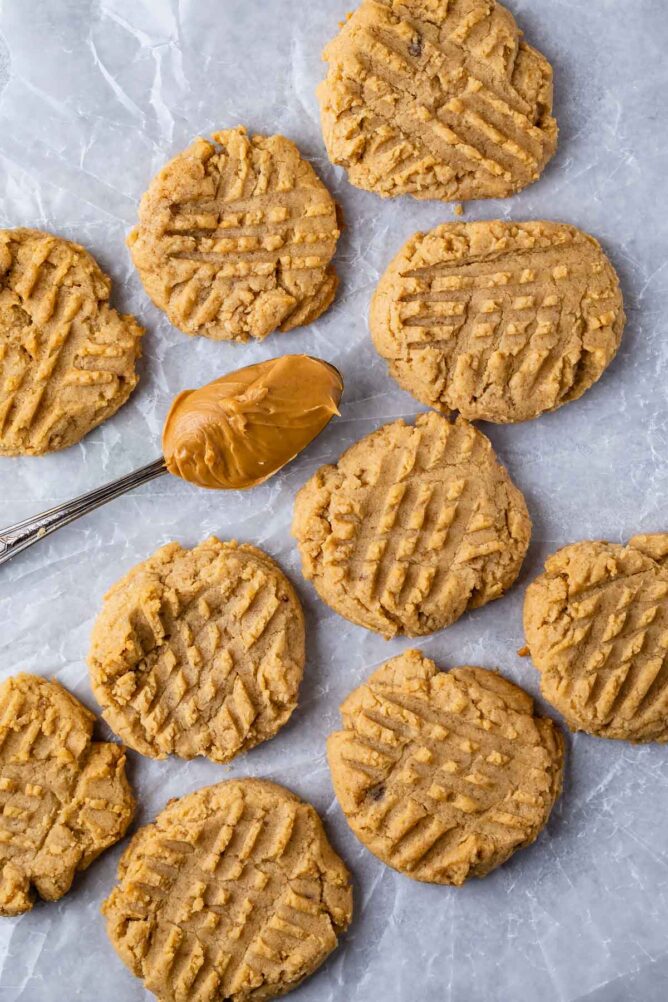 Overhead shot of 10 peanut butter cookies with a spoonful of peanut butter