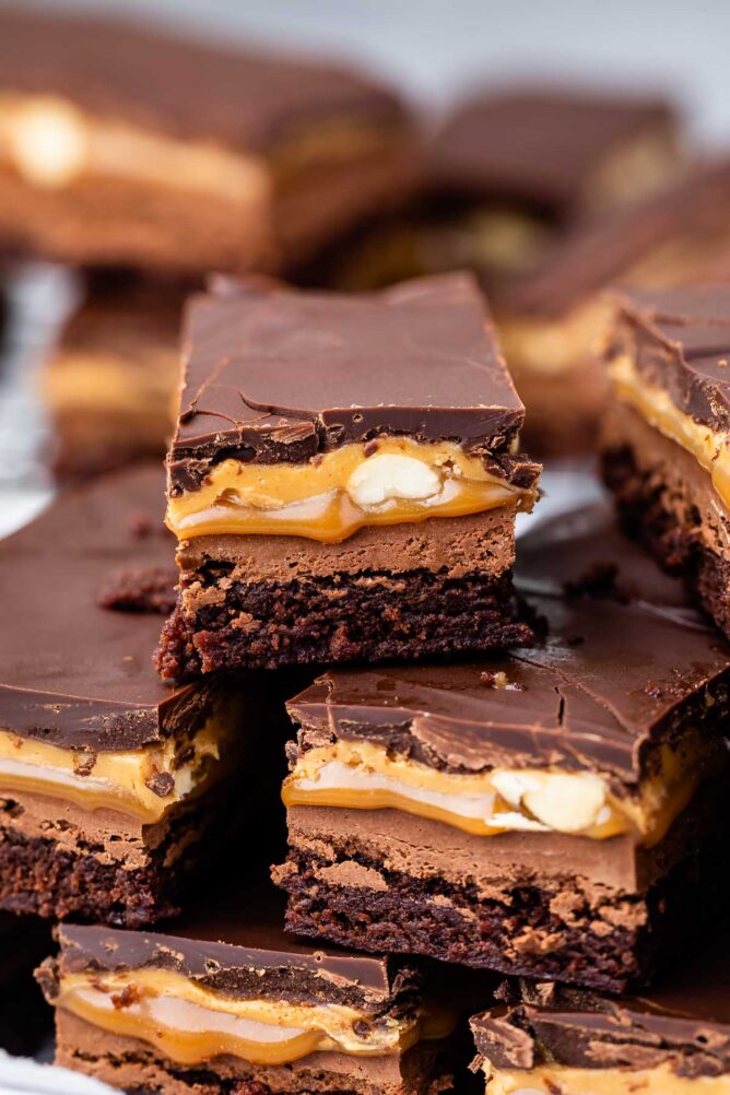 Snickers Brownies stacked on a plate
