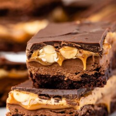Close up shot of two snicker brownie bars stacked on top of eachother