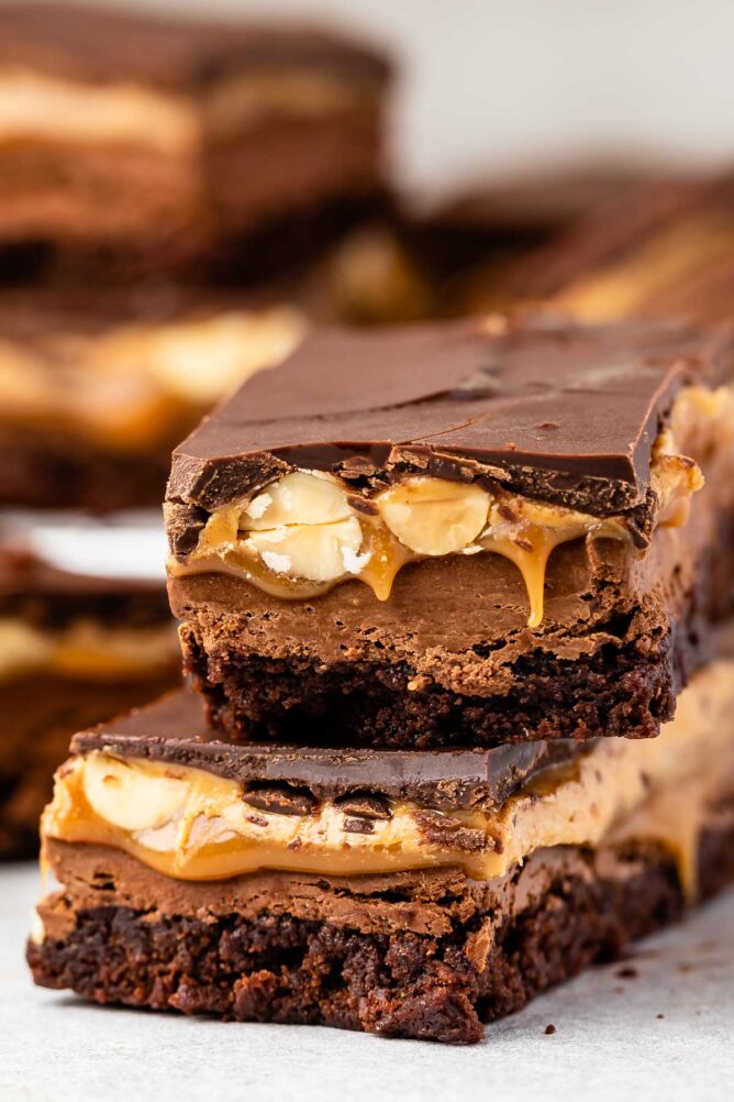 Close up shot of two snicker brownie bars stacked on top of eachother