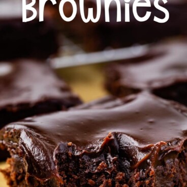 Close up shot of a double fudge brownie with corner bite missing and recipe title on top of image