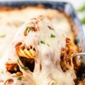 A spoonful of meatball casserole being pulled from casserole dish with recipe title on top of image