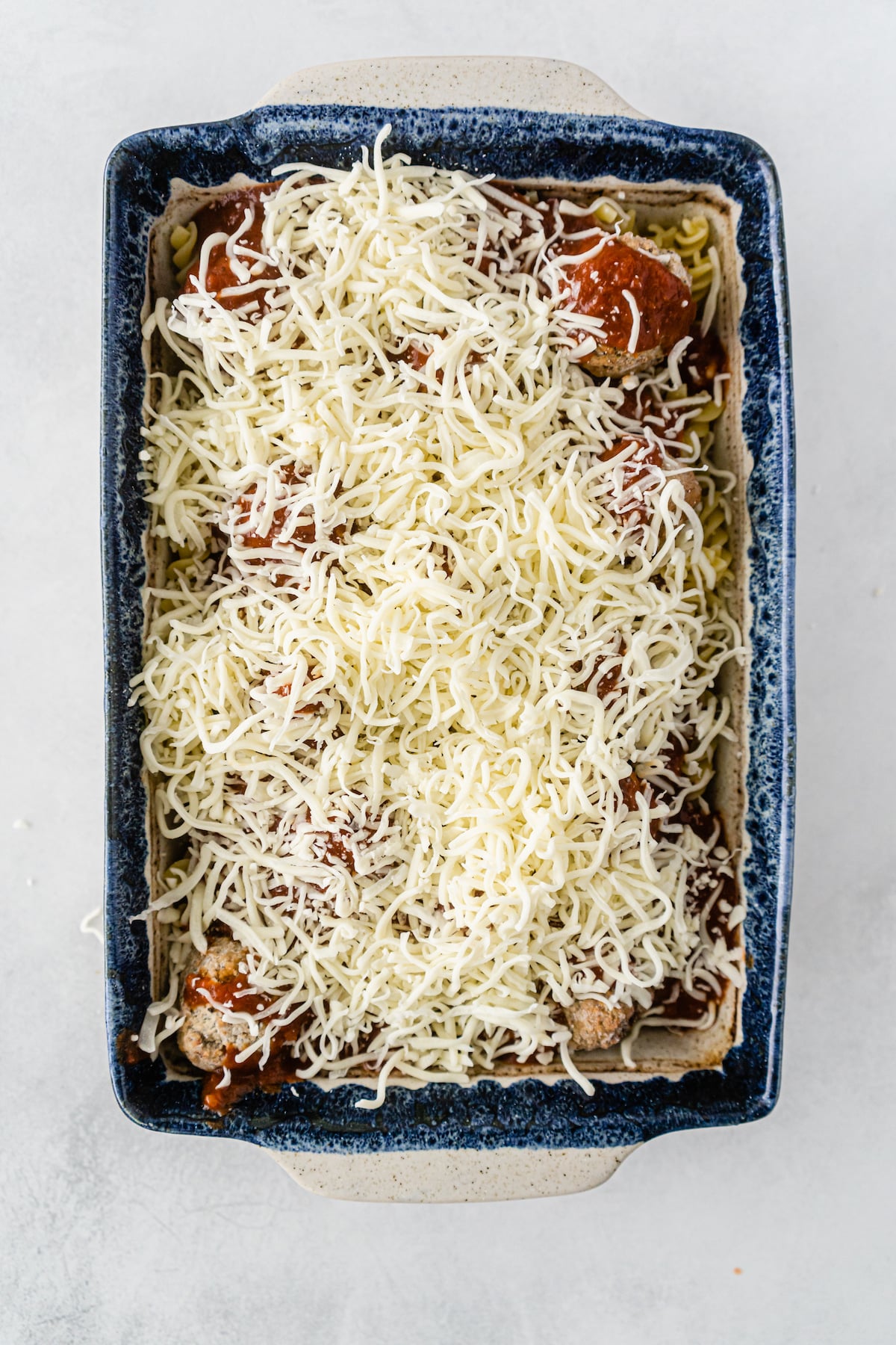 casserole with cheese unbaked in dish.