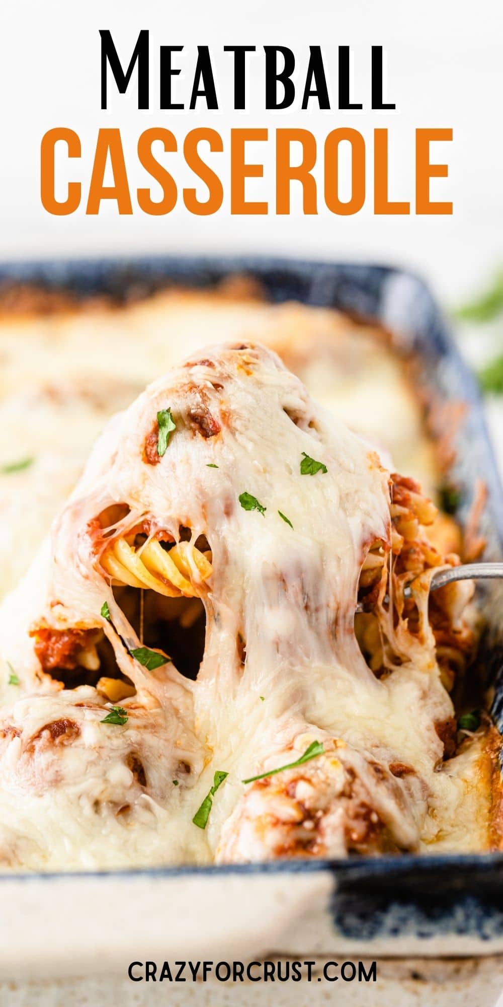 A spoonful of meatball casserole being pulled from casserole dish with recipe title on top of image