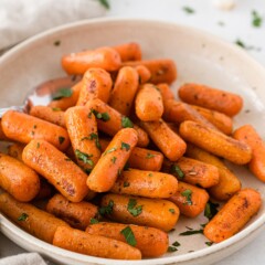 Roasted carrots in a white serving bowl