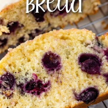Overhead shot of lemon blueberry bread slice on wire rack with recipe title on top of image