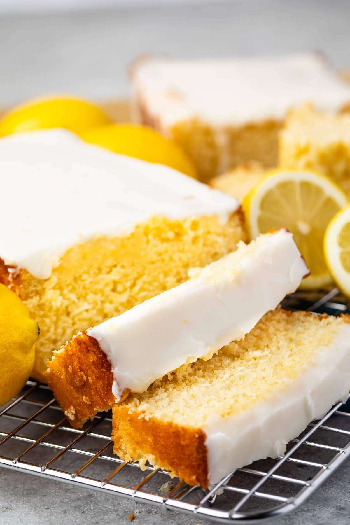 Lemon pound cake with two slices cut off on a metal wire rack