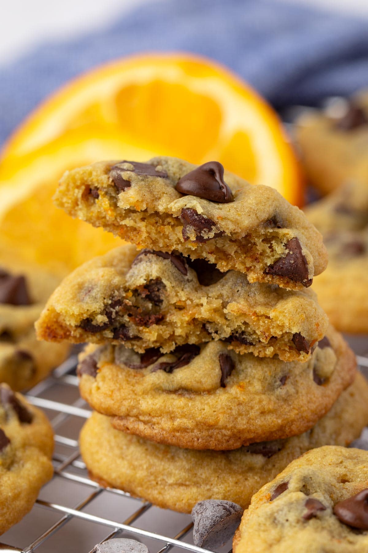 Stack of chocolate chip orange cookies with top one split in half to show inside