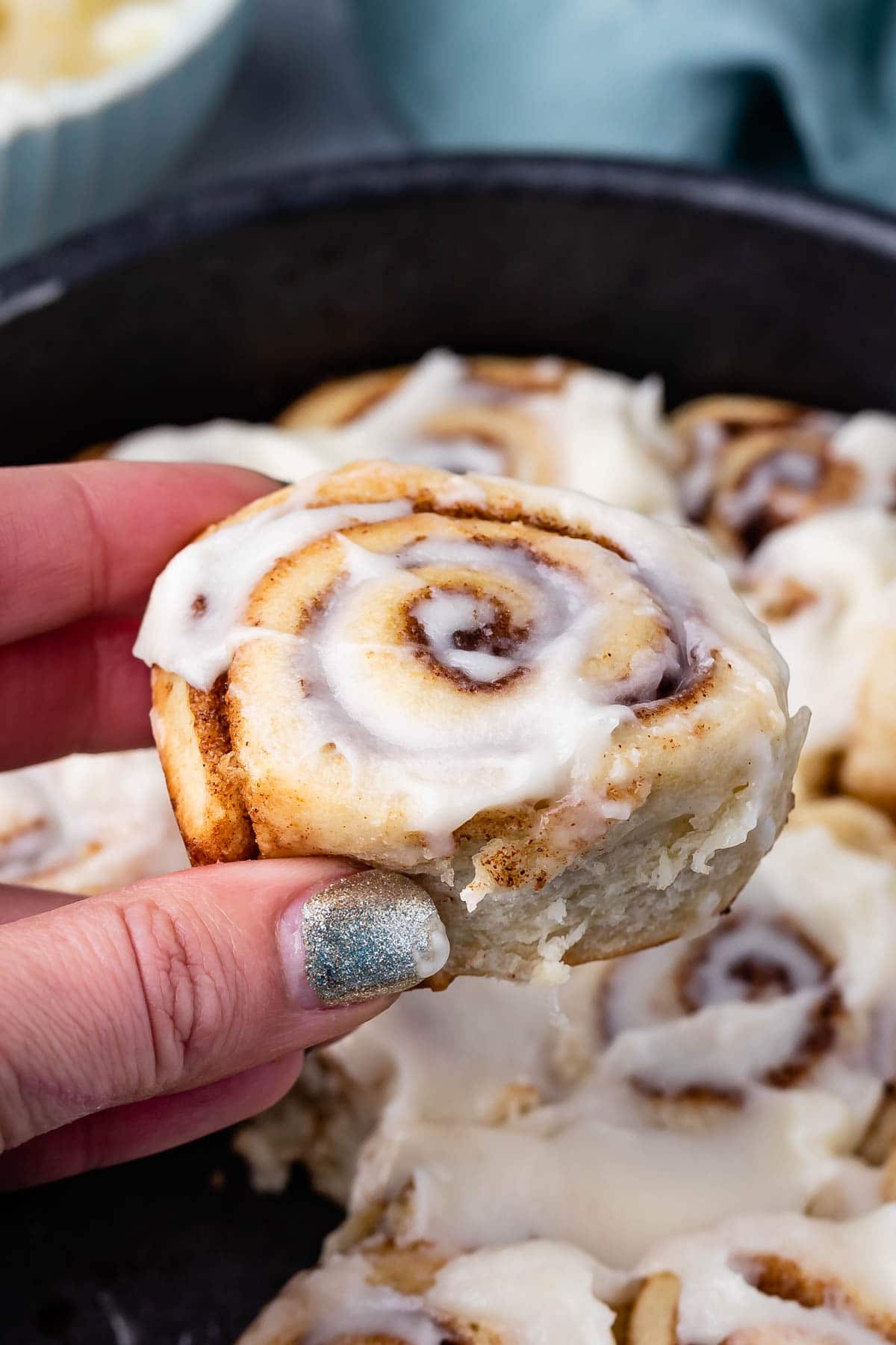 hand holding cinnamon roll