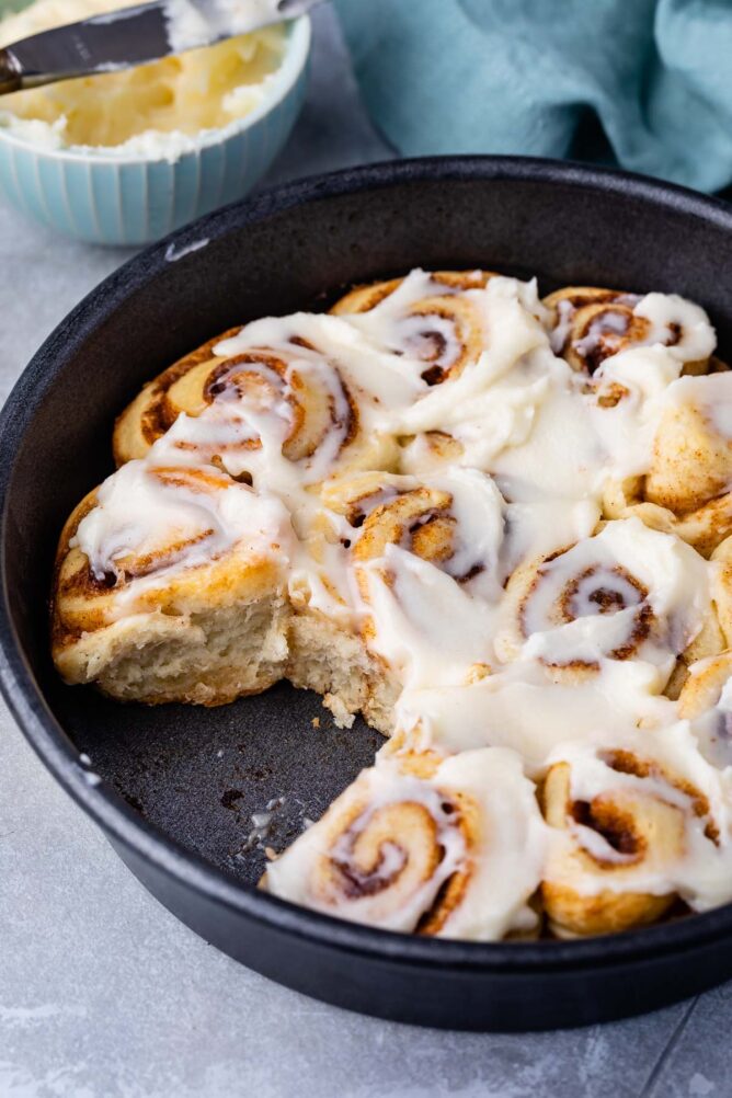 cinnamon rolls in pan with one missing
