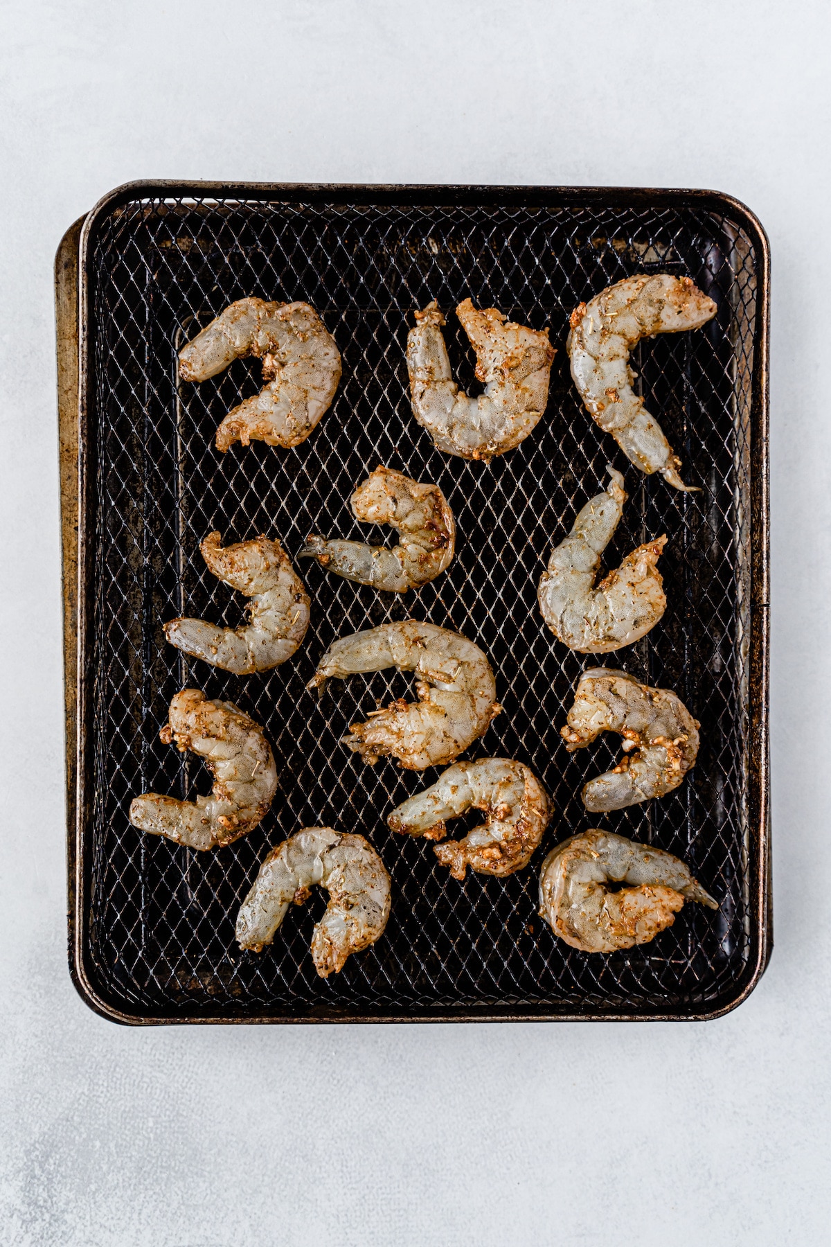 Air fryer shrimp on air fryer tray before being cooked