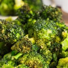 Plate full of air fryer broccoli with recipe title on top of image