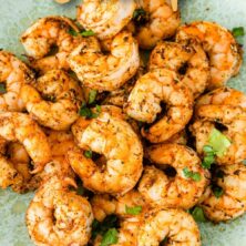 Air fryer shrimp on a plate with recipe title on top of image