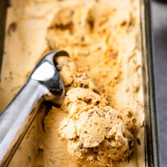 Dulce de leche ice cream being scooped out of container