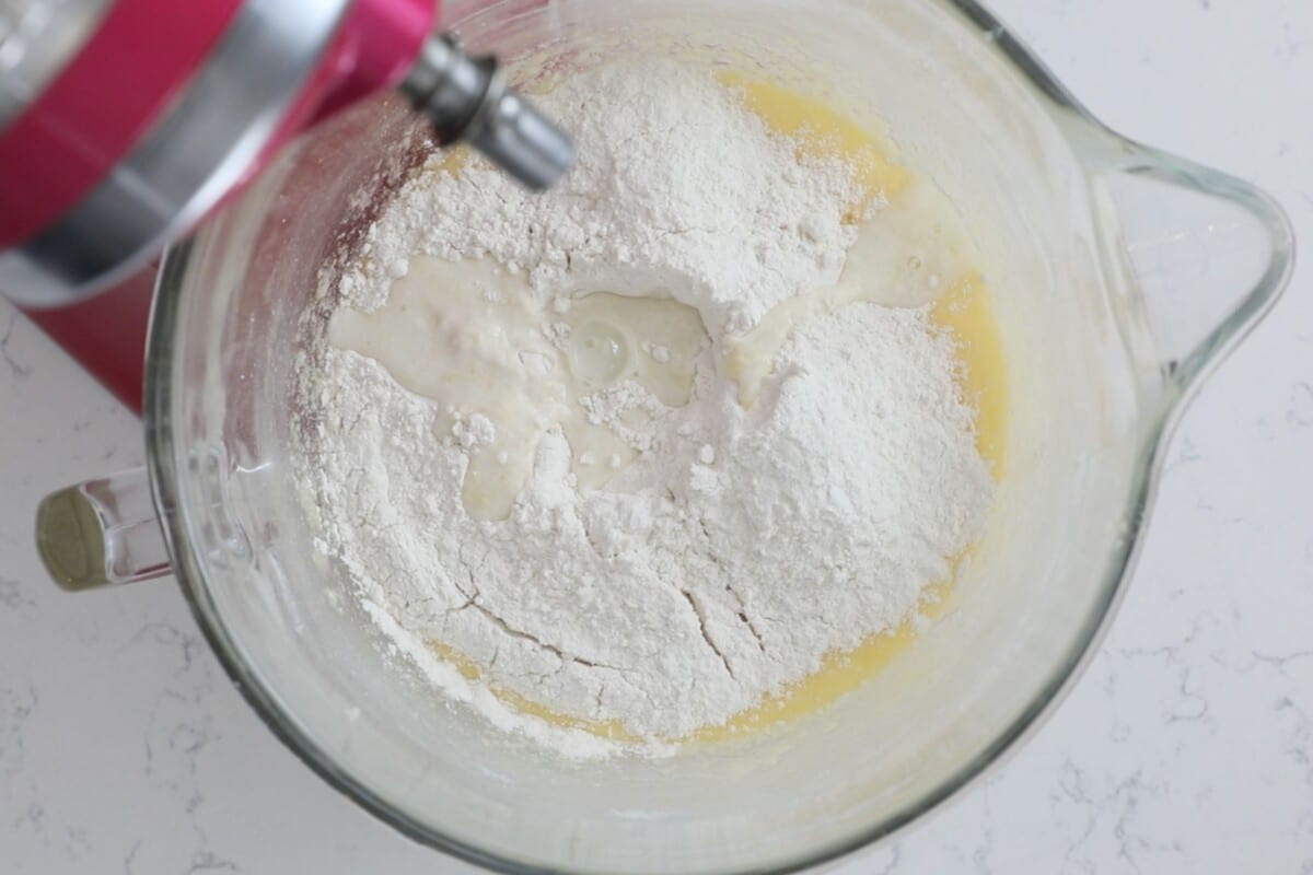 cake batter with flour and milk in stand mixer bowl.