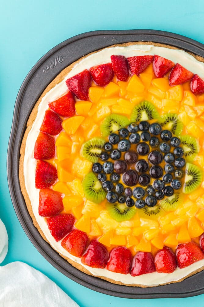 fruit pizza in pan on blue background