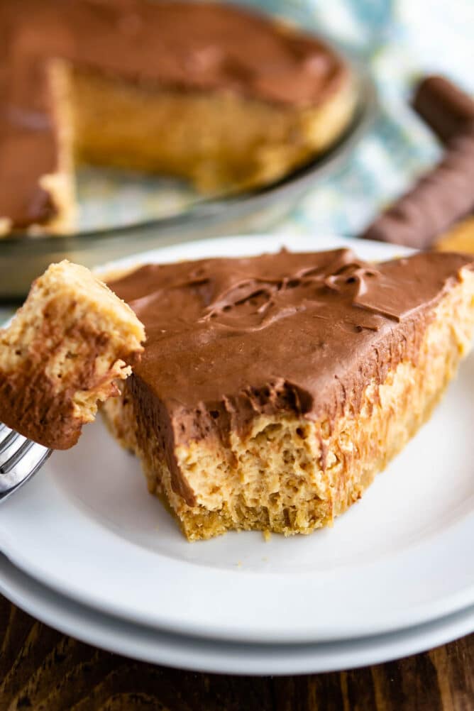 One slice of no bake peanut butter twix pie with bite missing