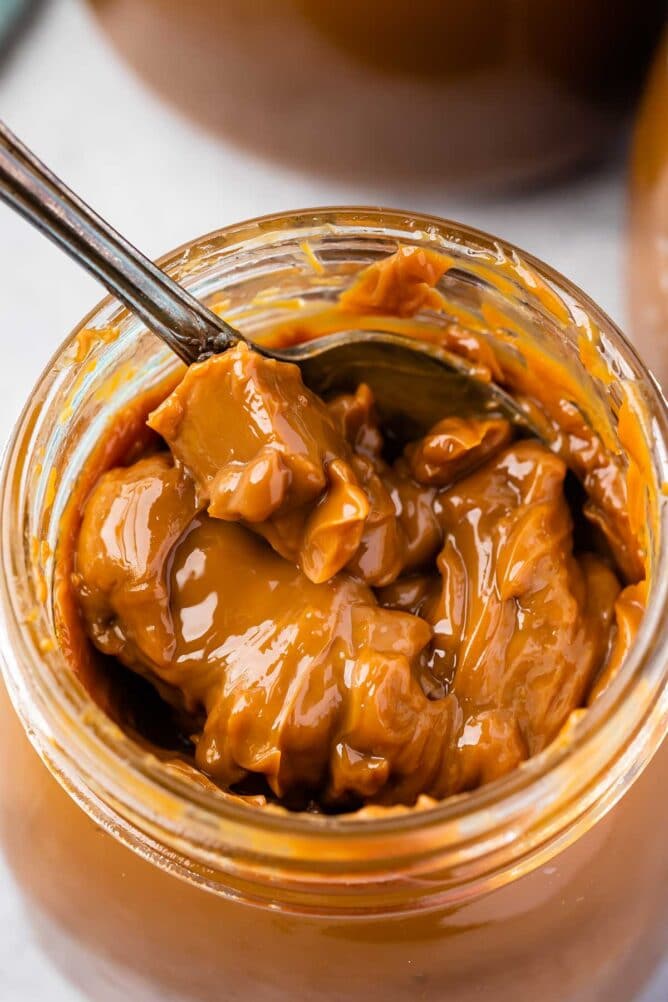 Overhead shot of a spoon inside a jar of dulce de leche