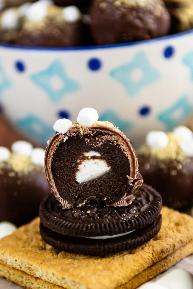 S'more oreo truffle sitting on an oreo cut in half to show mini marshmallow in the inside