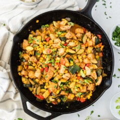 Overhead shot of bbq chicken skillet in cast iron skillet with more ingredients around it