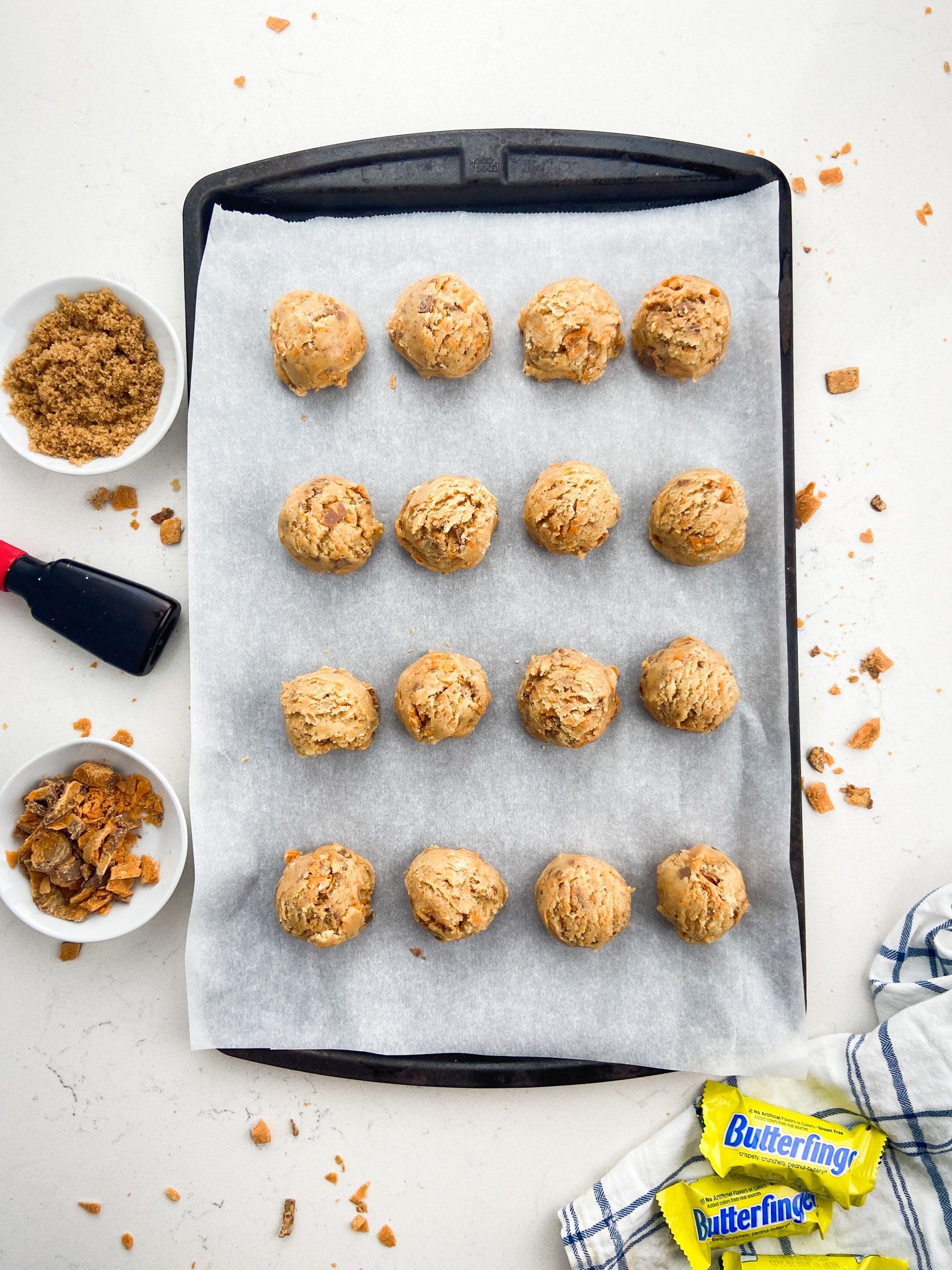 cookie sheet with parchment paper and 16 cookie dough balls