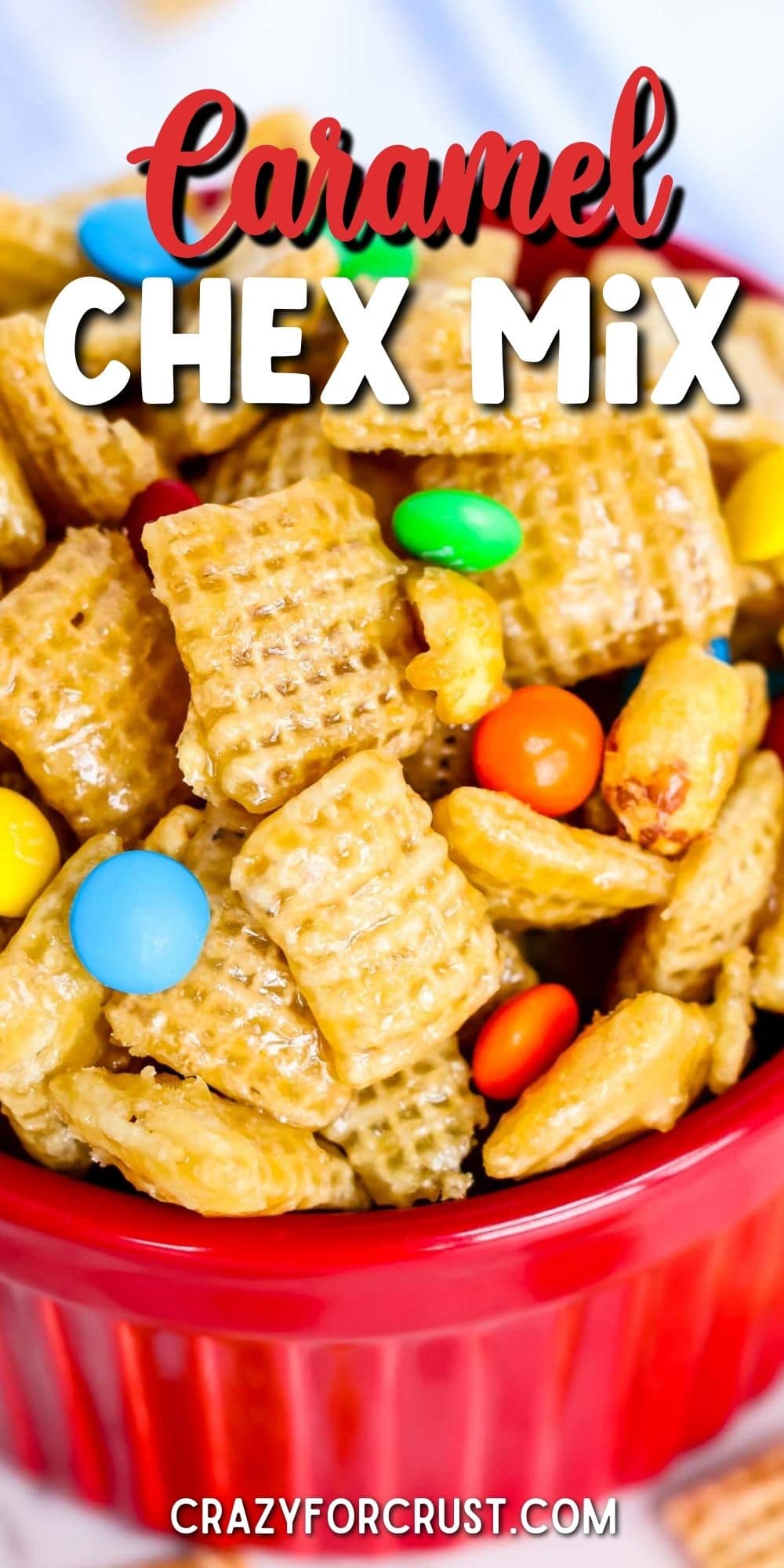 Small red bowl filled with caramel chex mix with recipe title on top of image