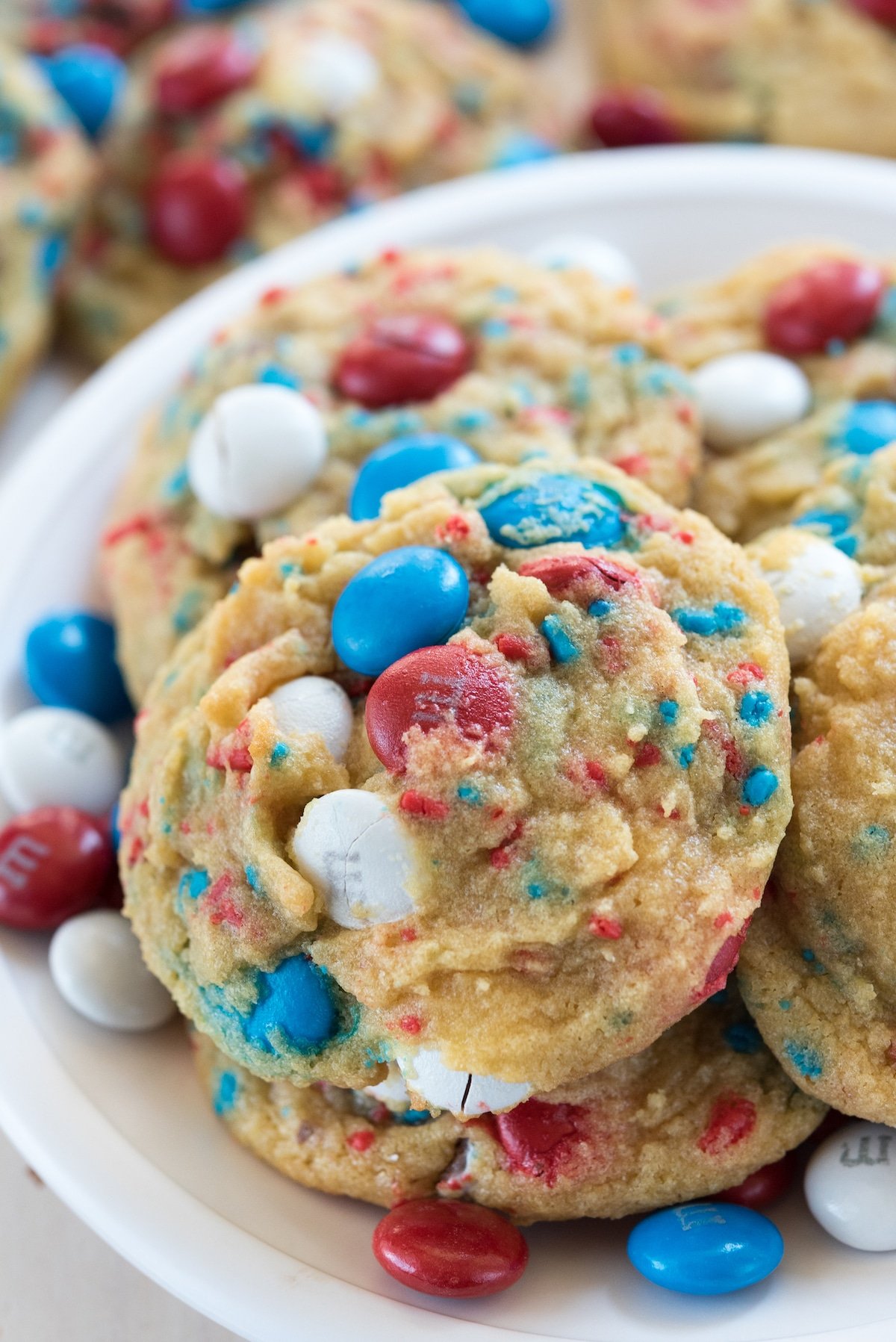 white plate with pile of cookies with red white and blue M&Ms