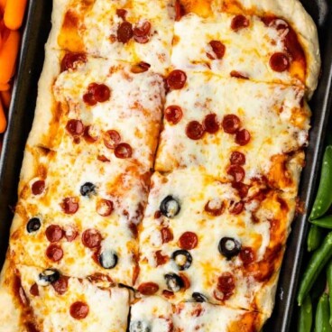 sheet pan pizza surrounded by vegetables