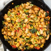 Overhead shot of bbq chicken skillet in cast iron with recipe title on top of image