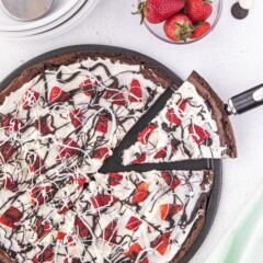 Overhead shot of brownie pizza with one slice being pulled away from the full pizza