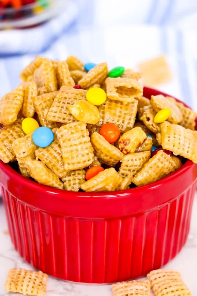 Small red bowl filled with caramel chex mix