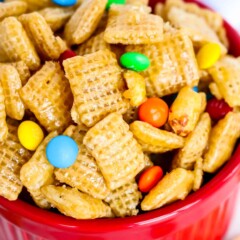 Close up shot of small red bowl filled with caramel chex mix