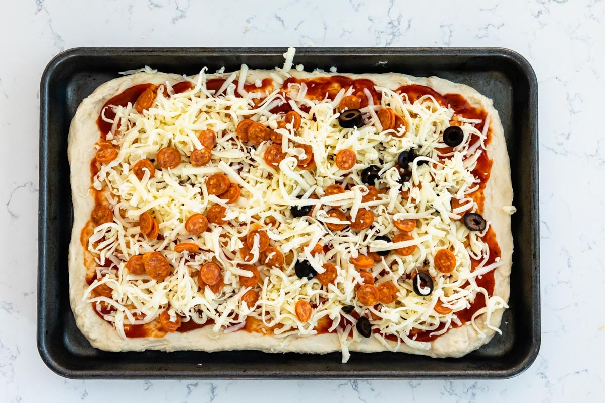 Sheet pan pizza with all the toppings before being cooked
