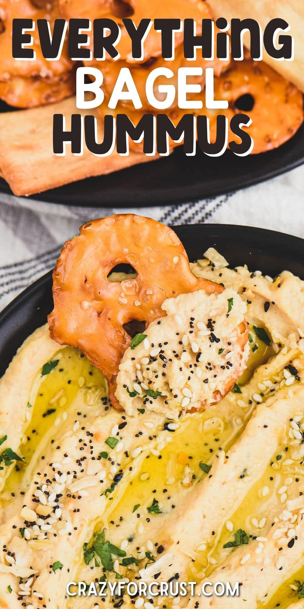 Pretzel chip being dipped into everything hummus with recipe title on top of image