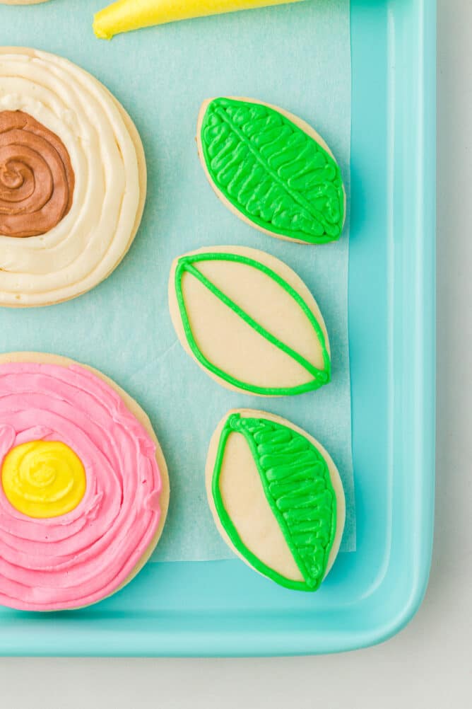 Overhead shot of leaf sugar cookies half decorated