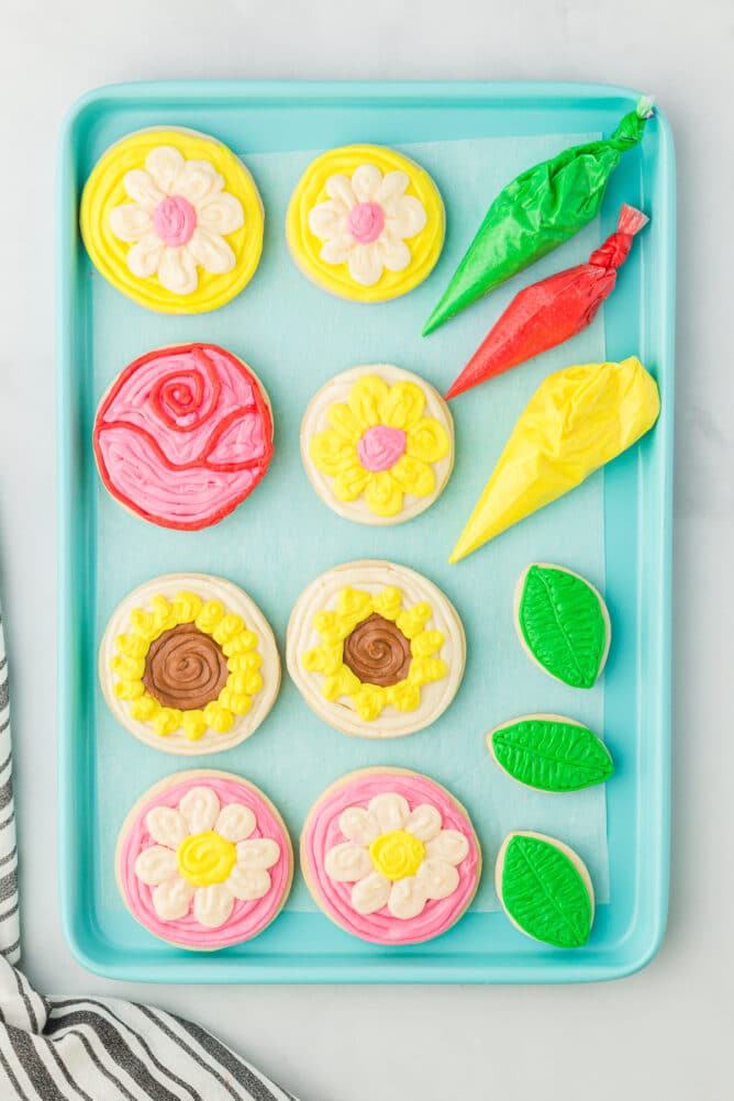 Overhead shot of all mother's day flower cookies decorated on a turquoise tray