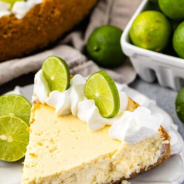 cheesecake on white plate with limes