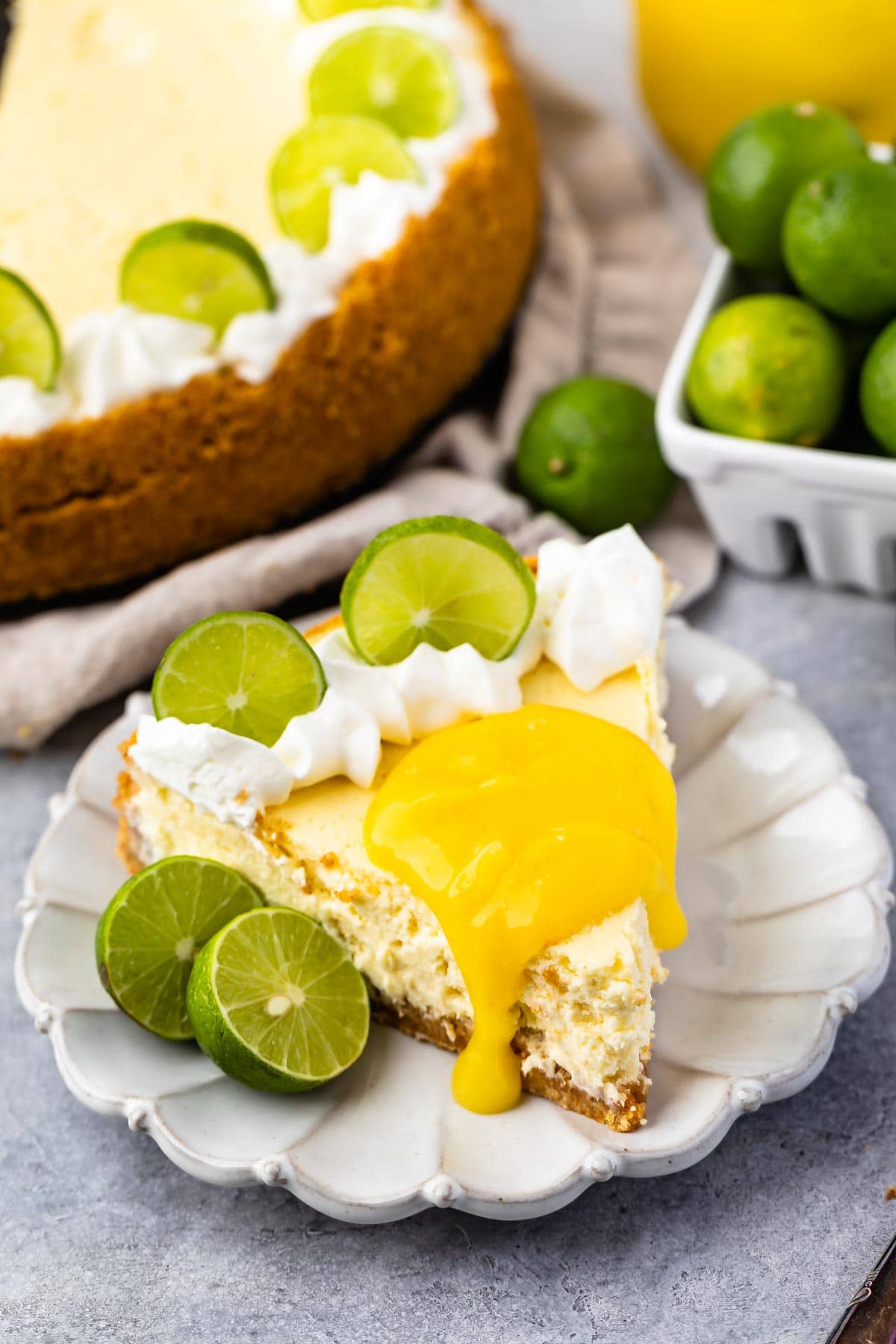 slice of cheesecake on white plate with lime curd on top