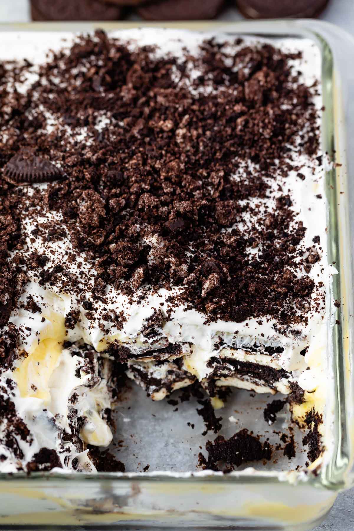 Oreo Lasagna in glass pan with a few servings missing