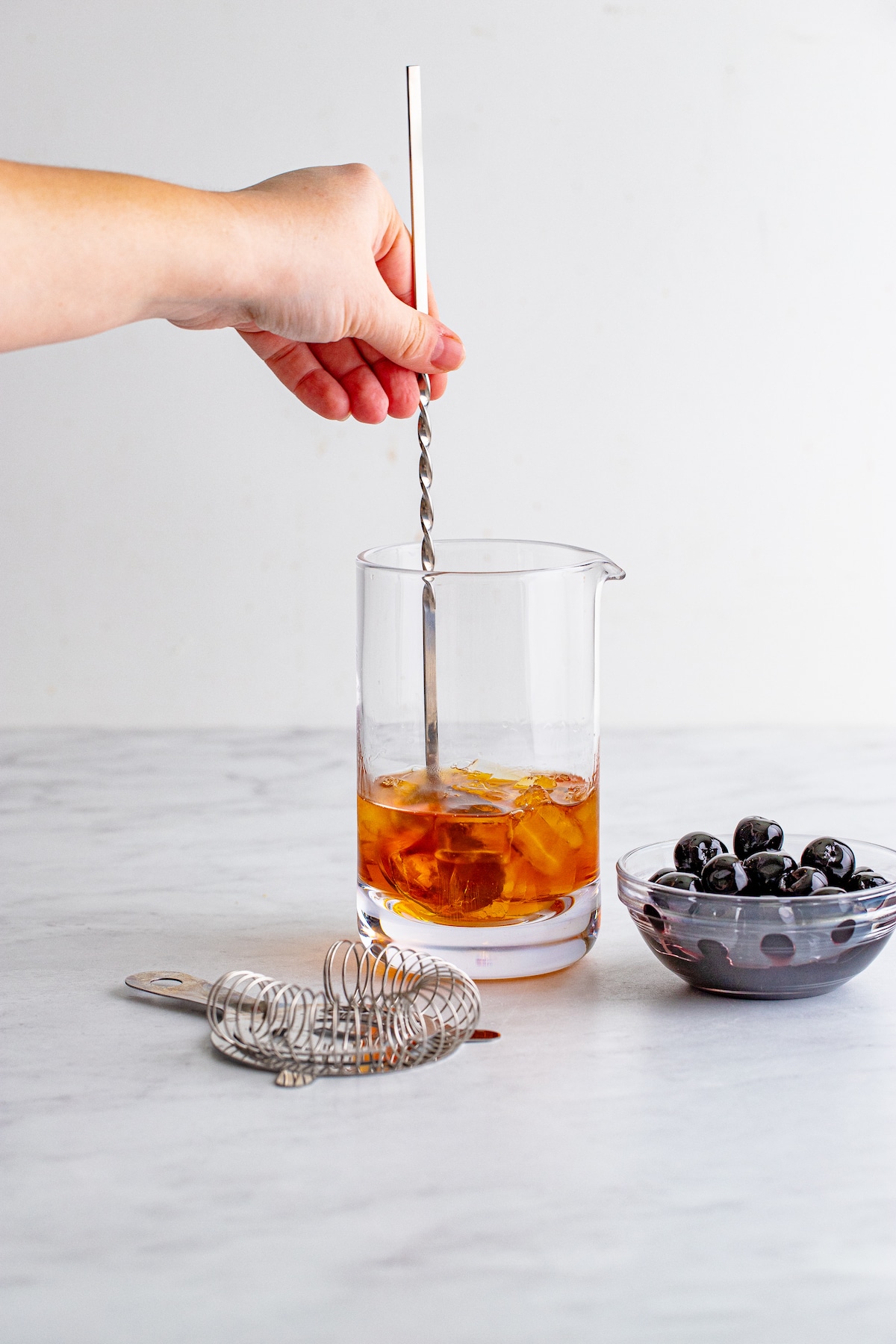 Manhattan cocktail in a pitcher being stirred