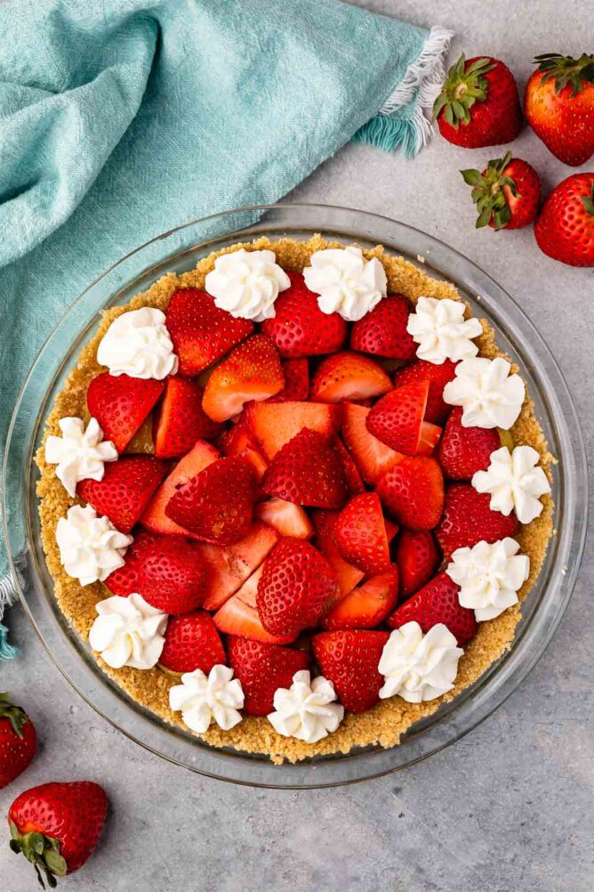 Overhead shot of no bake strawberry shortcake pie topped with whipped cream dollops