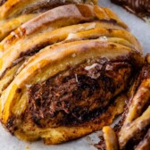 Chocolate cinnamon roll pull apart bread on parchment paper with one piece pulled off