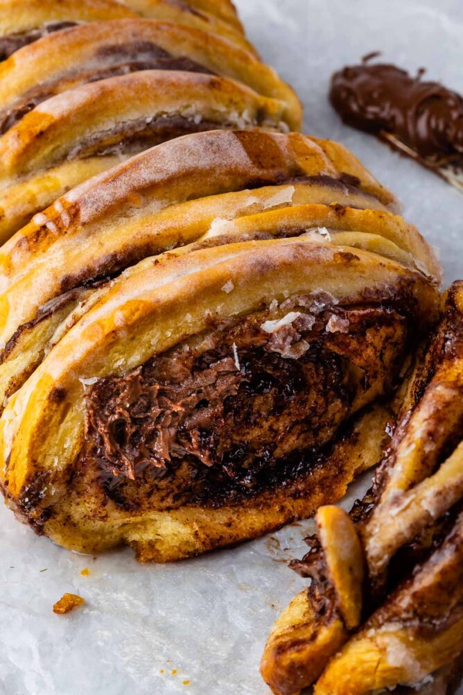 Chocolate cinnamon roll pull apart bread on parchment paper with one piece pulled off
