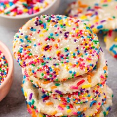 Four 2 ingredient sprinkle sugar cookies stacked on top of eachother