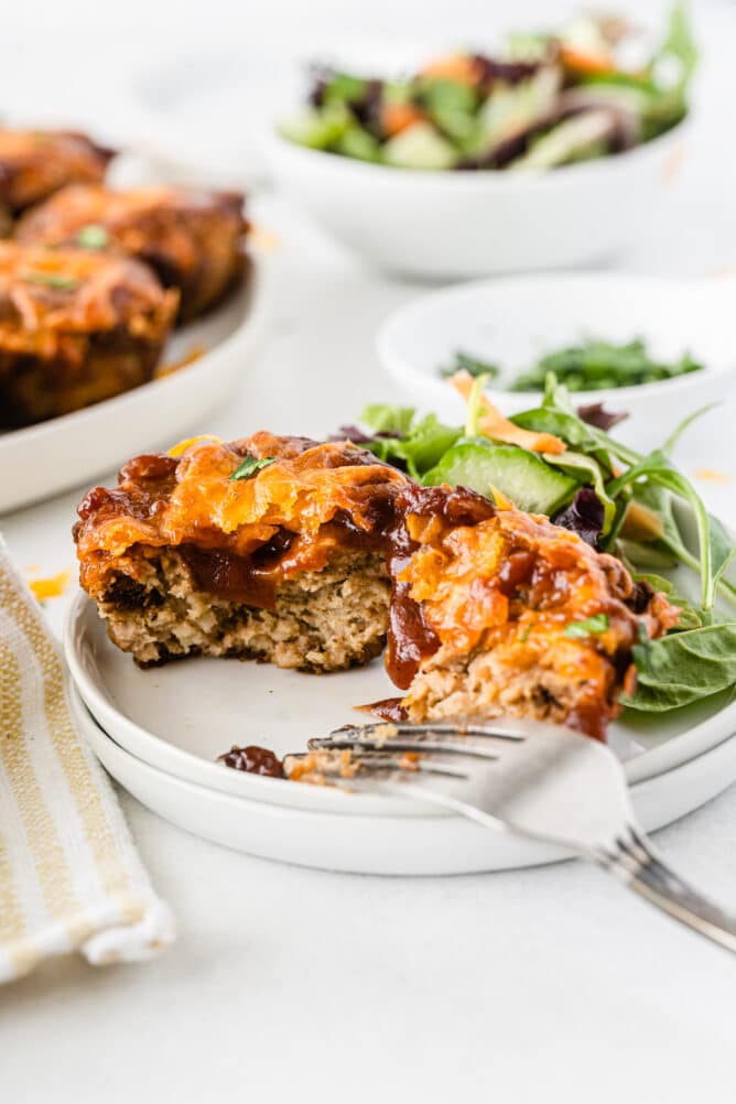 Mini BBQ Meatloaf cut in half on a plate next to salad