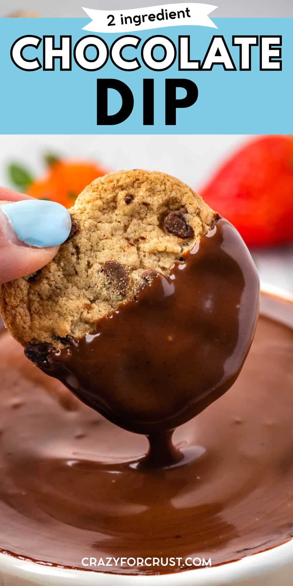 A hand dips a chocolate chip cookie into a bowl of rich chocolate dip, with a strawberry in the background. Text at the top reads “2 ingredient Chocolate Dip.”.