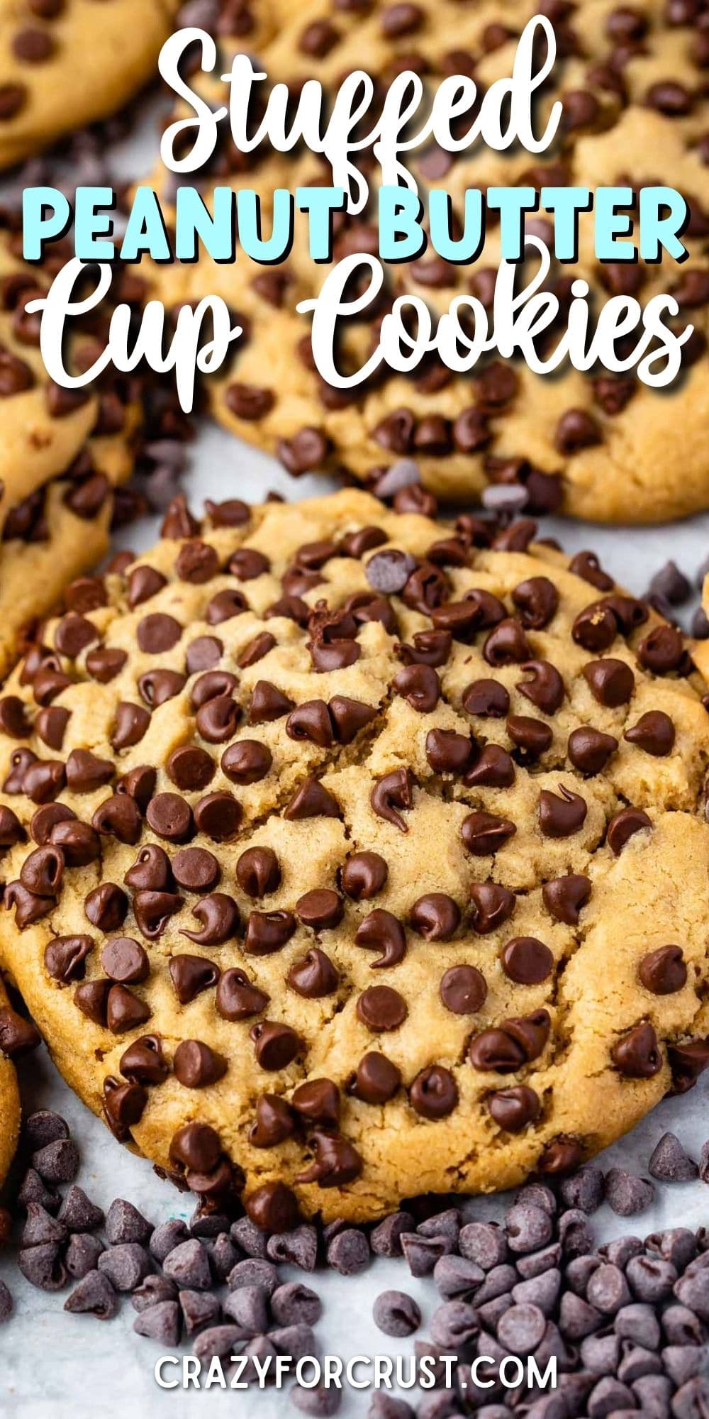 Close up overhead shot of ultimate stuffed peanut butter cookies on parchment paper surrounded by mini chocolate chips with recipe title on top of image