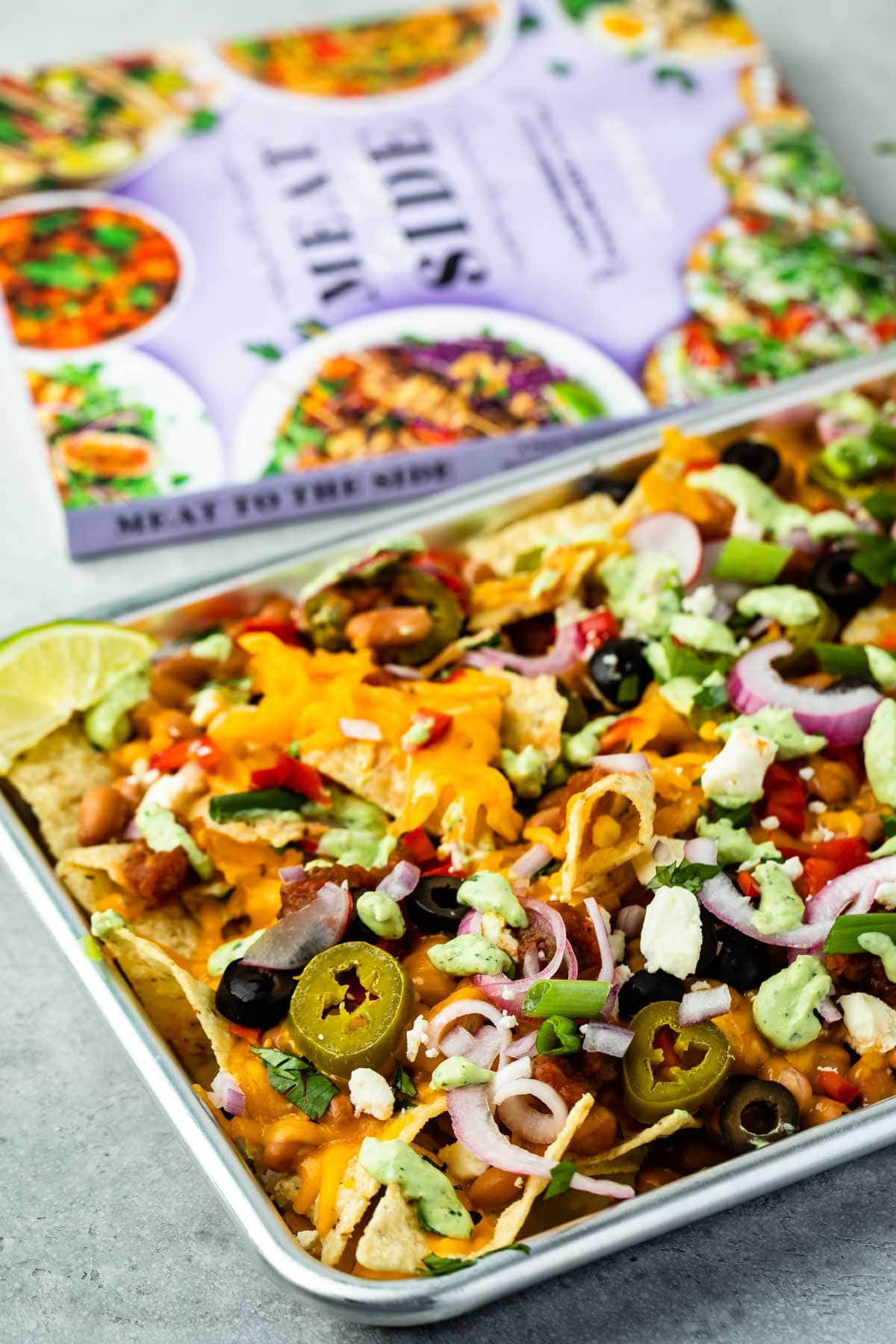 Veggie sheet pan nachos next to a cookbook